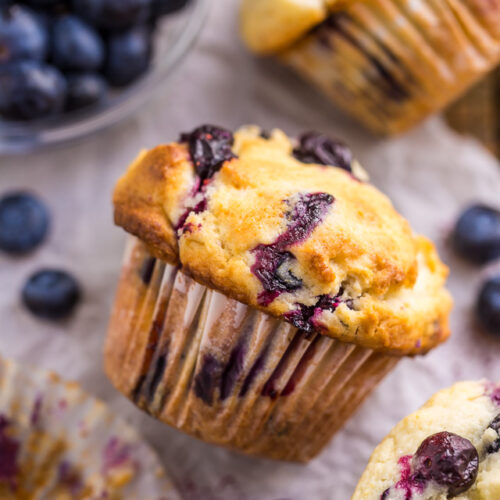 Blueberry muffin on a piece of parchment paper.