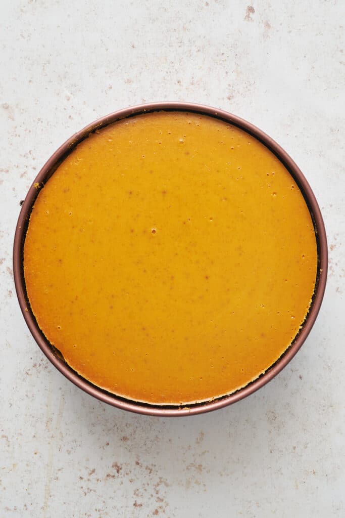 Baked pumpkin cheesecake in a springform pan.