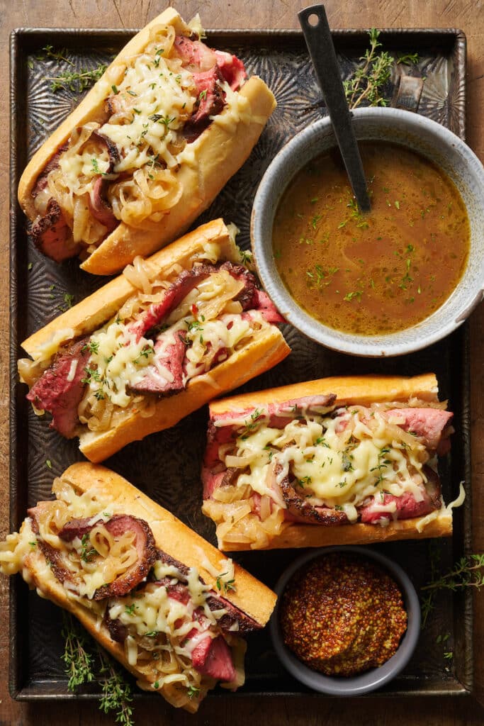 French rolls stuffed with thinly sliced roast beef and cheese for French dip sandwiches.