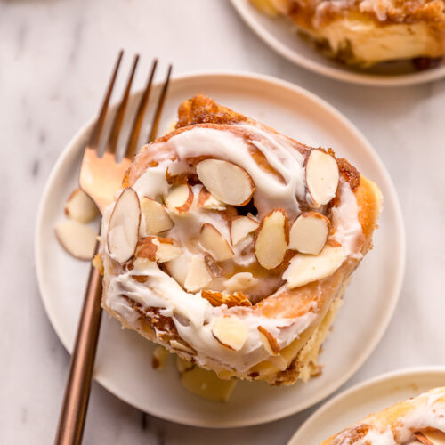 Triple Almond Cinnamon Rolls are the ultimate breakfast treat! This indulgent recipe features soft and fluffy yeasted buns that are filled with brown sugar cinnamon filling and topped with a sticky sweet glaze and slivered almonds! This homemade almond cinnamon roll recipe is a MUST for all of the almond lovers out there!
