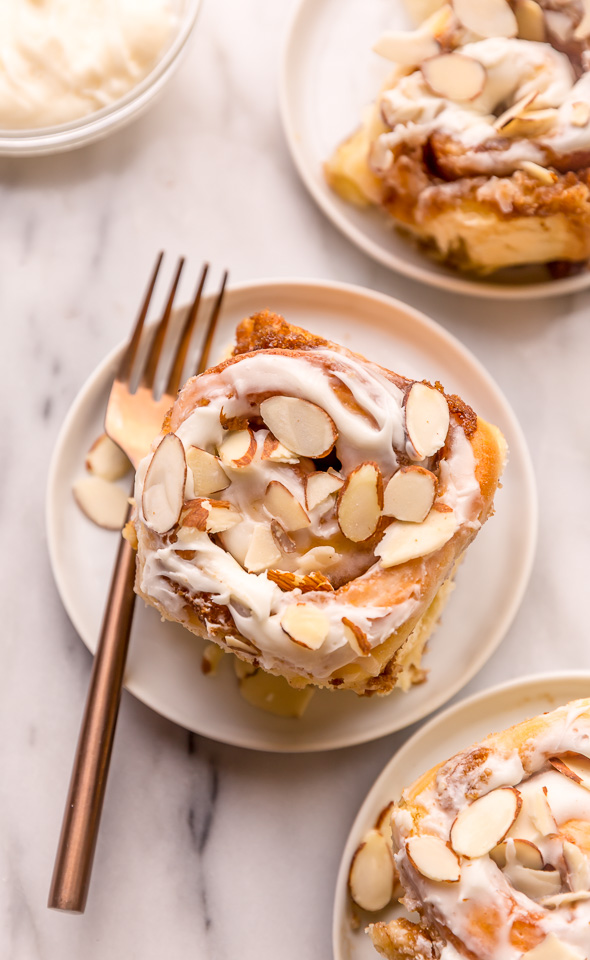 Triple Almond Cinnamon Rolls are the ultimate breakfast treat! This indulgent recipe features soft and fluffy yeasted buns that are filled with brown sugar cinnamon filling and topped with a sticky sweet glaze and slivered almonds! This homemade almond cinnamon roll recipe is a MUST for all of the almond lovers out there!