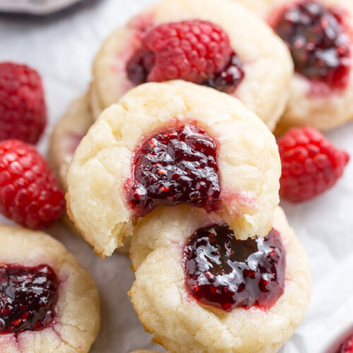 Raspberry thumbprint cookies with a bite taken out of it.