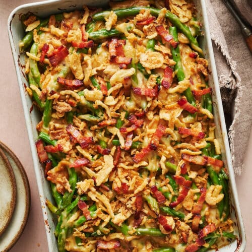 Baking dish with green bean casserole topped with crispy fried onions.