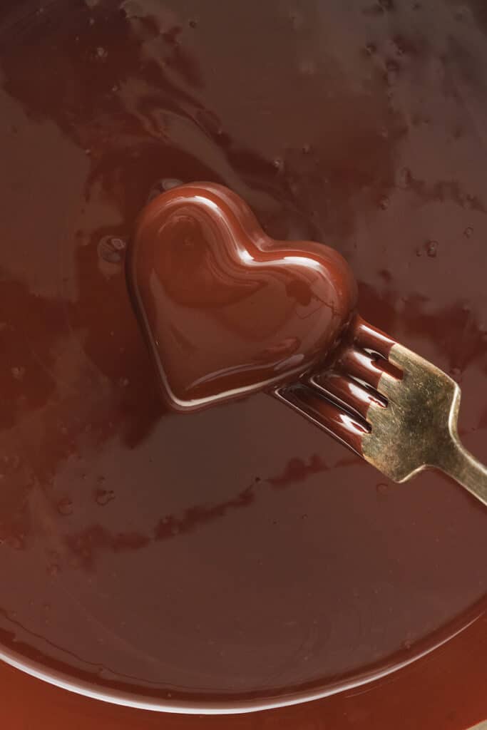 Dipping peanut butter hearts into