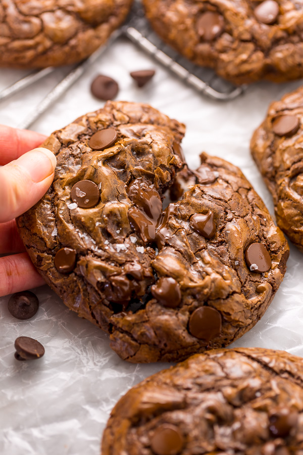 Chocolate Cookies being picked up off parchment paper.
