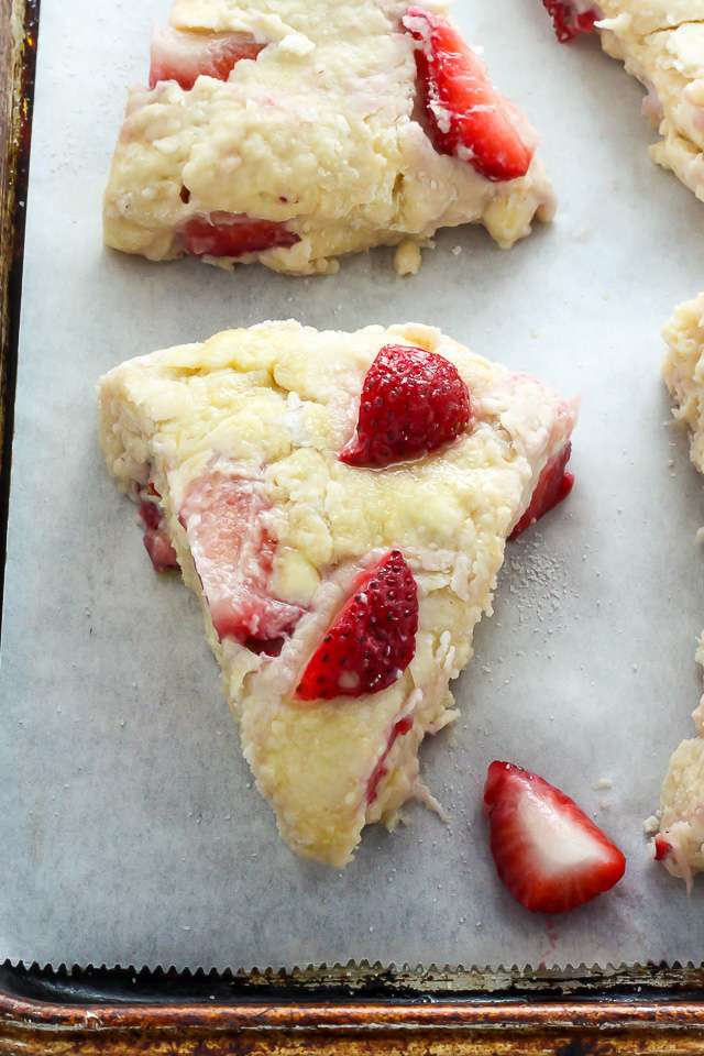 Strawberry scone dough cut and put on parchment paper lined baking sheet.