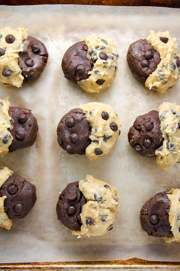 Chocolate chip cookie dough swirled with brownie batter for brookies on a parchment paper lined baking sheet.
