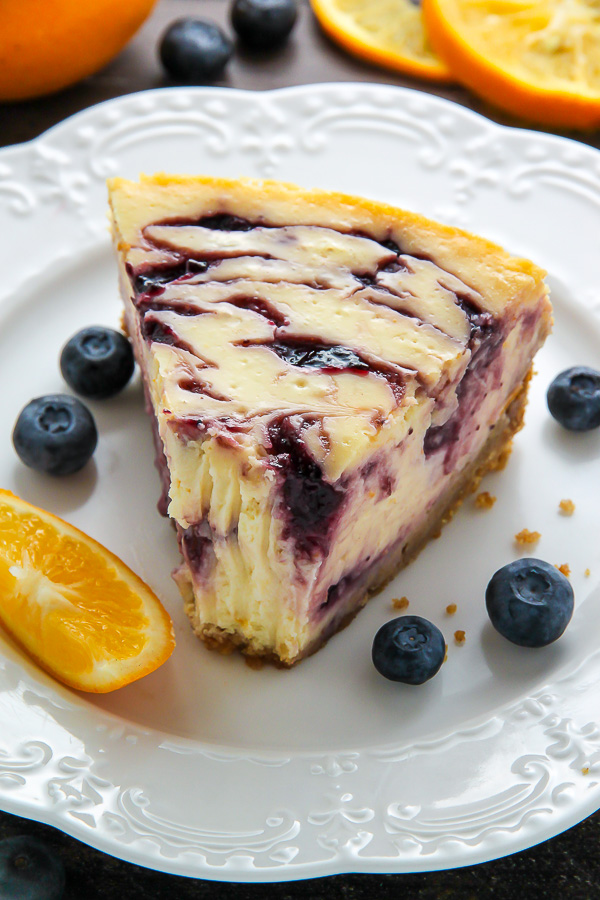 Supremely smooth and creamy homemade Lemon cheesecake topped with fresh Blueberry swirls. All layered on top of a buttery homemade graham cracker crust.