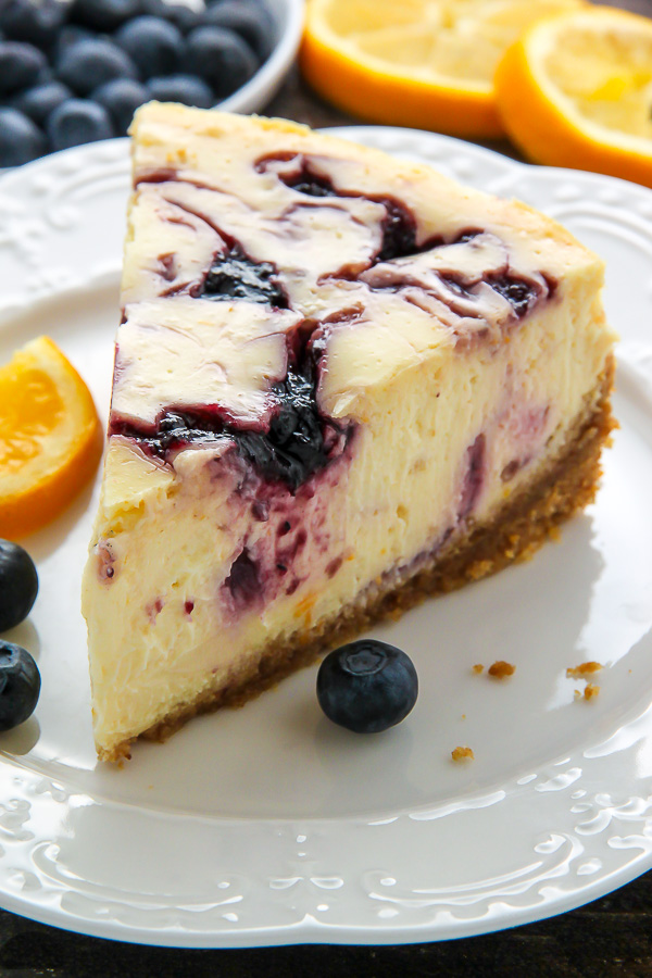 Supremely smooth and creamy homemade Lemon cheesecake topped with fresh Blueberry swirls. All layered on top of a buttery homemade graham cracker crust.
