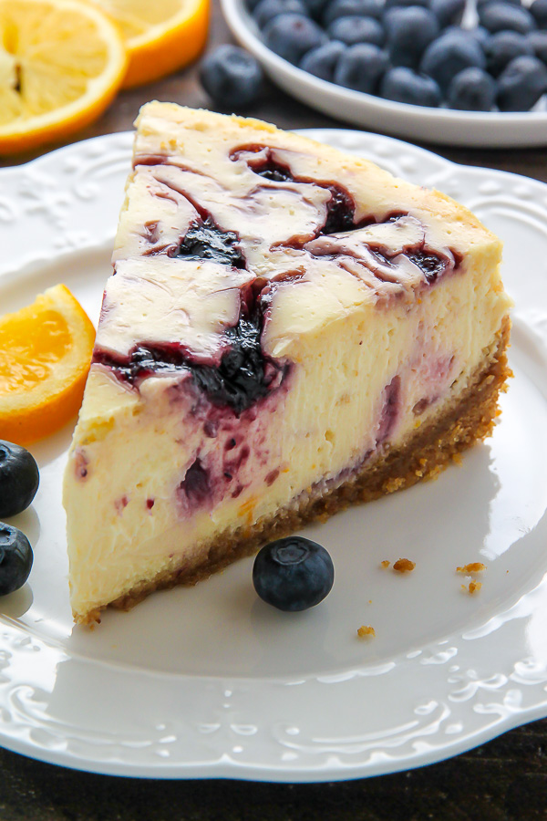 Supremely smooth and creamy homemade Lemon cheesecake topped with fresh Blueberry swirls. All layered on top of a buttery homemade graham cracker crust.