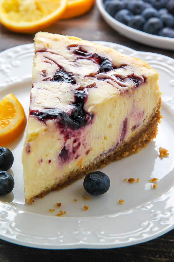 Supremely smooth and creamy homemade Lemon cheesecake topped with fresh Blueberry swirls. All layered on top of a buttery homemade graham cracker crust.