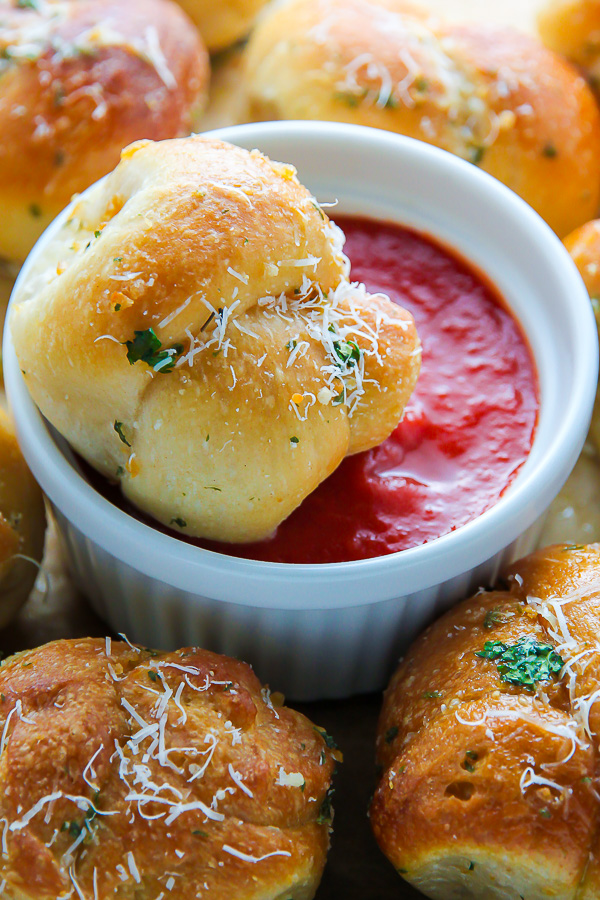 Garlic knots with a side of marinara sauce for dipping.