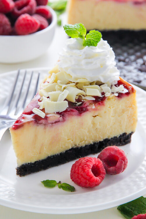 Creamy White Chocolate Cheesecake swirled with fresh raspberry, all on top of a homemade chocolate cookie crust. This one is a showstopper!
