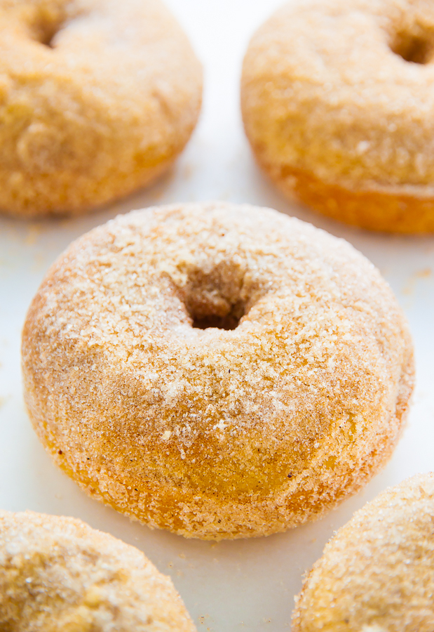 Baked cinnamon sugar donut on a white piece of parchment paper.