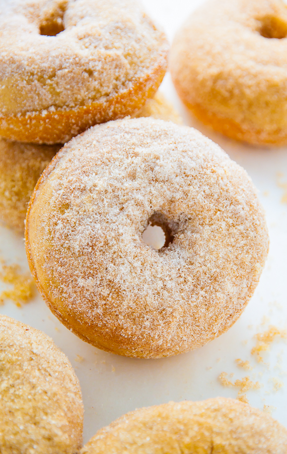 Baked cinnamon sugar donut on a white piece of parchment paper.
