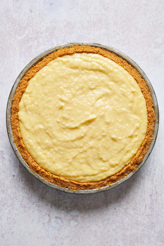 Graham cracker crust filled with creamy coconut filling for coconut cream pie recipe.