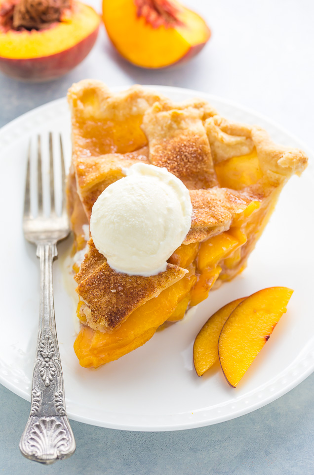 A slice of brown sugar cinnamon peach pie with ice cream on top.