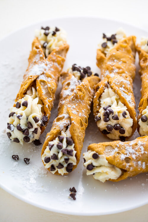 Cannoli with chocolate chips on a white plate.