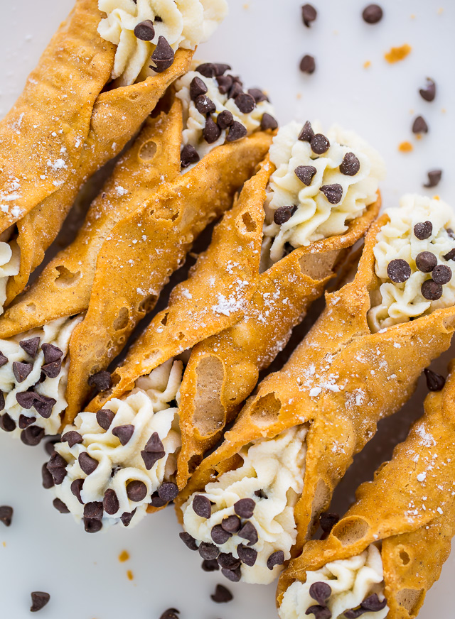 Cannoli on a white background surrounded by chocolate chips.