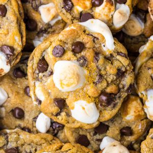 S'mores Chocolate Chip Cookies piled on top of each other with mini marshmallows on top.