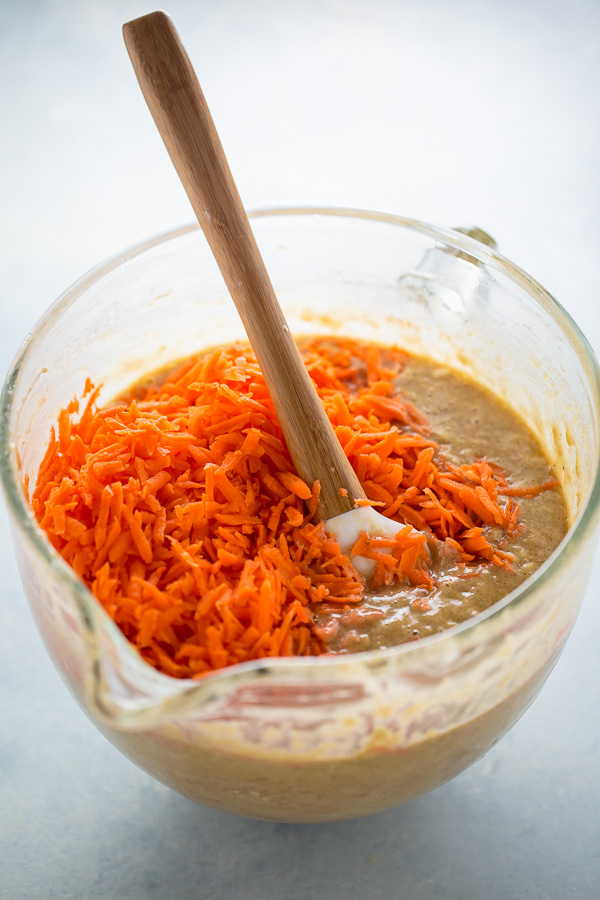 Bowl with cake batter topped with shredded carrots.