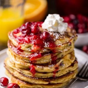 Fluffy and flavorful Cranberry Orange Pancakes are topped with Maple Cranberry Syrup!