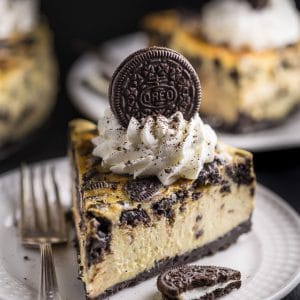Slice of oreo cheesecake on a white plate.