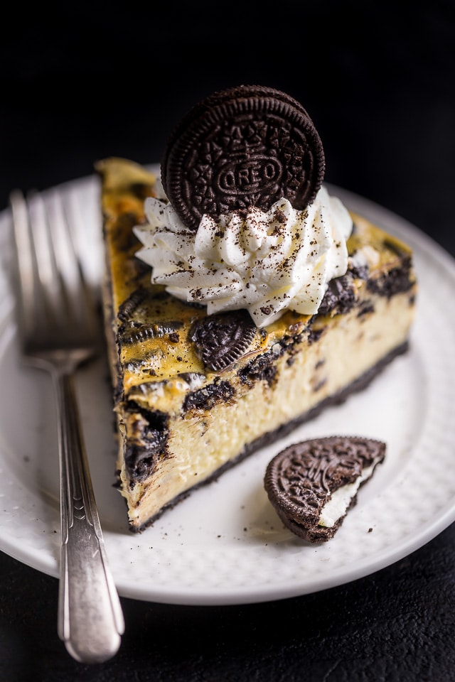 Slice of oreo cheesecake with oreo crust on a dessert plate.