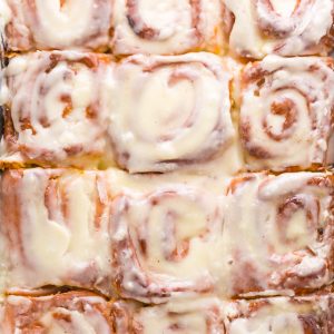 Homemade Cinnamon Rolls in a baking dish with glaze on top.