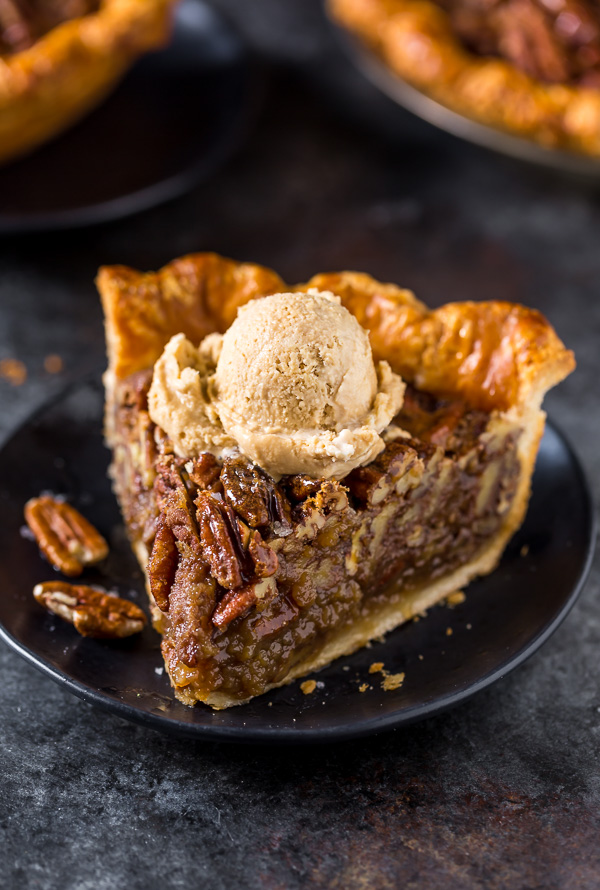 Slice of pecan pie with ice cream on top.
