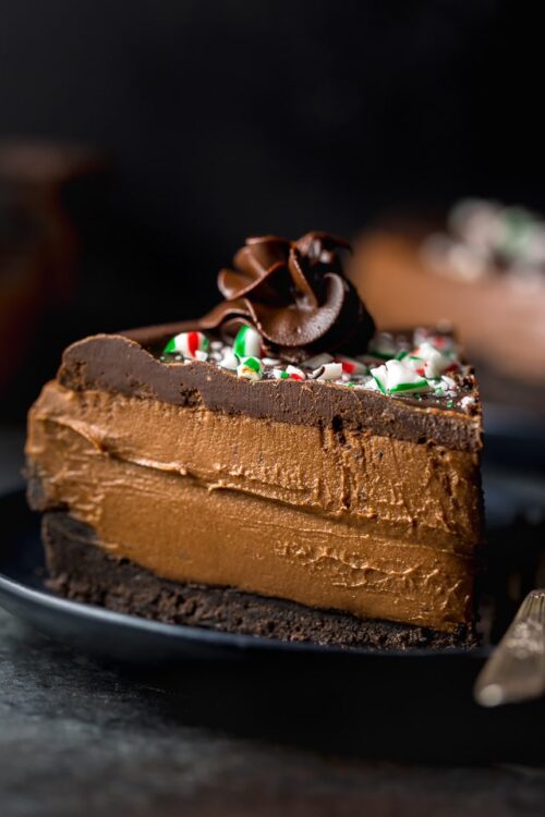 This No-Bake Peppermint Mocha Cheesecake is rich, creamy, and so flavorful! Topped with chocolate ganache and crushed candy canes, this chocolate peppermint cheesecake is seriously festive and perfect for holiday celebrations. #peppermintmocha #cheesecake #chocolate #Christmas #peppermint