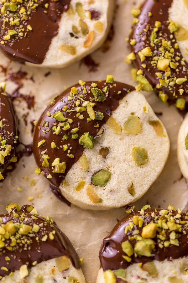 Dark Chocolate Pistachio Slice & Bake Cookies are so easy and made with just 6 ingredients! These buttery shortbread cookies are loaded with pistachios and then dunked in dark chocolate. So good with a cup of coffee or tea!