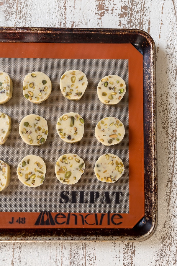 Dark Chocolate Pistachio Slice & Bake Cookies are so easy and made with just 6 ingredients! These buttery shortbread cookies are loaded with pistachios and then dunked in dark chocolate. So good with a cup of coffee or tea!