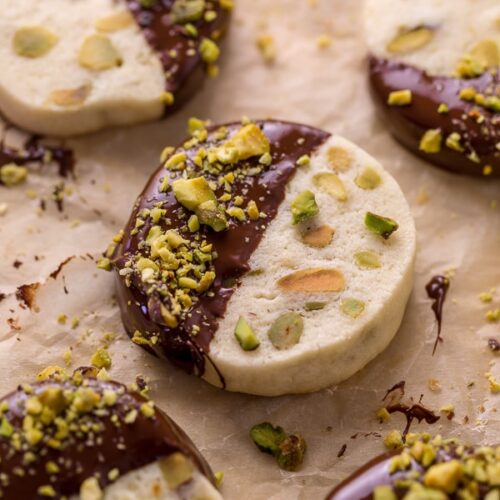 Dark Chocolate Pistachio Slice & Bake Cookies are so easy and made with just 6 ingredients! These buttery shortbread cookies are loaded with pistachios and then dunked in dark chocolate. So good with a cup of coffee or tea!