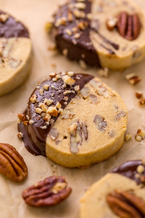 Place the pistachios in a small bowl and cover with water; set aside for 30 minutes. Drain the pistachios well and place them on a paper towel to air dry while you assemble the cookie dough. In the bowl of a stand mixer fitted with the paddle attachment, or in a large bowl using a handheld electric mixer, combine the butter and sugar and beat on medium-high speed until pale and fluffy. Add in the egg and beat until combined. Add in the flour and pistachios and beat until combined. Your dough should be stiff. Sprinkle 2 Tablespoons of flour over a clean work surface. Scrape the cookie dough onto the surface and gently knead it for 30 seconds. Divide the dough in half, then roll each portion of cookie dough into a log that's roughly 2" in diameter. Wrap each log tightly in plastic wrap and refrigerate for at least 2 hours (or up to 5 days). When you're ready to bake, preheat the oven to 350 degrees (F). Line a large baking sheet with parchment paper or a Silpat baking mat. Remove the dough from the fridge and place it on a cutting board. Using a sharp knife, slice the logs of cookie dough into 1/4" rounds. Place the cookies 1/2" apart on the prepared baking sheet, and bake for 10 to 12 minutes, or until lightly golden. Remove the oven and place the pan on a cooling rack. Cool for at least 15 minutes before removing. In the meantime, make the chocolate coating. Melt the chopped chocolate in a double boiler or in the microwave. If using the microwave method, place the chopped chocolate in a medium heat-proof bowl. Melt in the microwave, on low power, in 15 second increments, stirring after each increment until completely melted and smooth. Dip each cookie halfway into the chocolate then return to the lined baking sheet. Sprinkle with sea salt or additional chopped pistachios, if desired. Allow the chocolate to set before serving. To speed this up, place the baking sheet into the refrigerator. Once set, serve and enjoy! These are really good with coffee or tea.