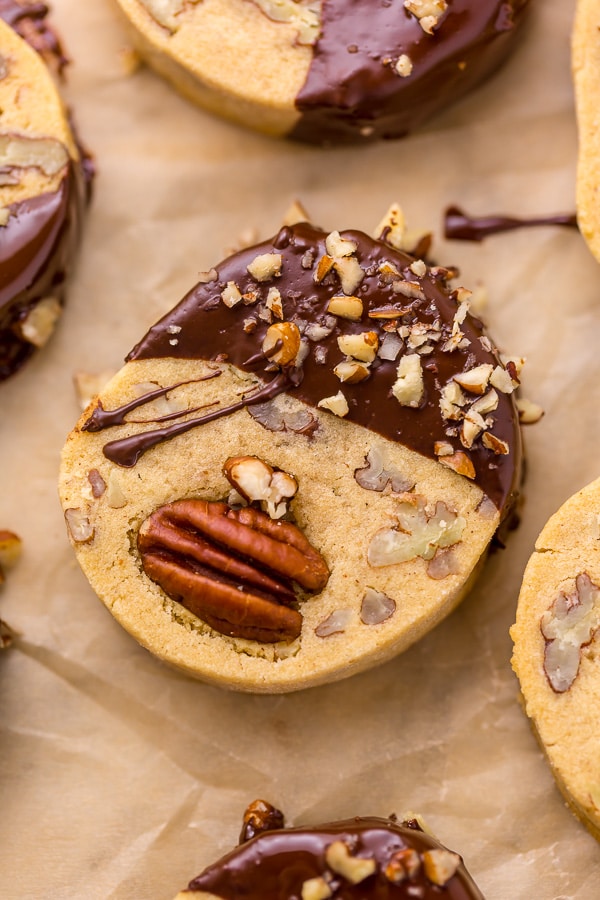 Place the pistachios in a small bowl and cover with water; set aside for 30 minutes. Drain the pistachios well and place them on a paper towel to air dry while you assemble the cookie dough. In the bowl of a stand mixer fitted with the paddle attachment, or in a large bowl using a handheld electric mixer, combine the butter and sugar and beat on medium-high speed until pale and fluffy. Add in the egg and beat until combined. Add in the flour and pistachios and beat until combined. Your dough should be stiff. Sprinkle 2 Tablespoons of flour over a clean work surface. Scrape the cookie dough onto the surface and gently knead it for 30 seconds. Divide the dough in half, then roll each portion of cookie dough into a log that's roughly 2" in diameter. Wrap each log tightly in plastic wrap and refrigerate for at least 2 hours (or up to 5 days). When you're ready to bake, preheat the oven to 350 degrees (F). Line a large baking sheet with parchment paper or a Silpat baking mat. Remove the dough from the fridge and place it on a cutting board. Using a sharp knife, slice the logs of cookie dough into 1/4" rounds. Place the cookies 1/2" apart on the prepared baking sheet, and bake for 10 to 12 minutes, or until lightly golden. Remove the oven and place the pan on a cooling rack. Cool for at least 15 minutes before removing. In the meantime, make the chocolate coating. Melt the chopped chocolate in a double boiler or in the microwave. If using the microwave method, place the chopped chocolate in a medium heat-proof bowl. Melt in the microwave, on low power, in 15 second increments, stirring after each increment until completely melted and smooth. Dip each cookie halfway into the chocolate then return to the lined baking sheet. Sprinkle with sea salt or additional chopped pistachios, if desired. Allow the chocolate to set before serving. To speed this up, place the baking sheet into the refrigerator. Once set, serve and enjoy! These are really good with coffee or tea.