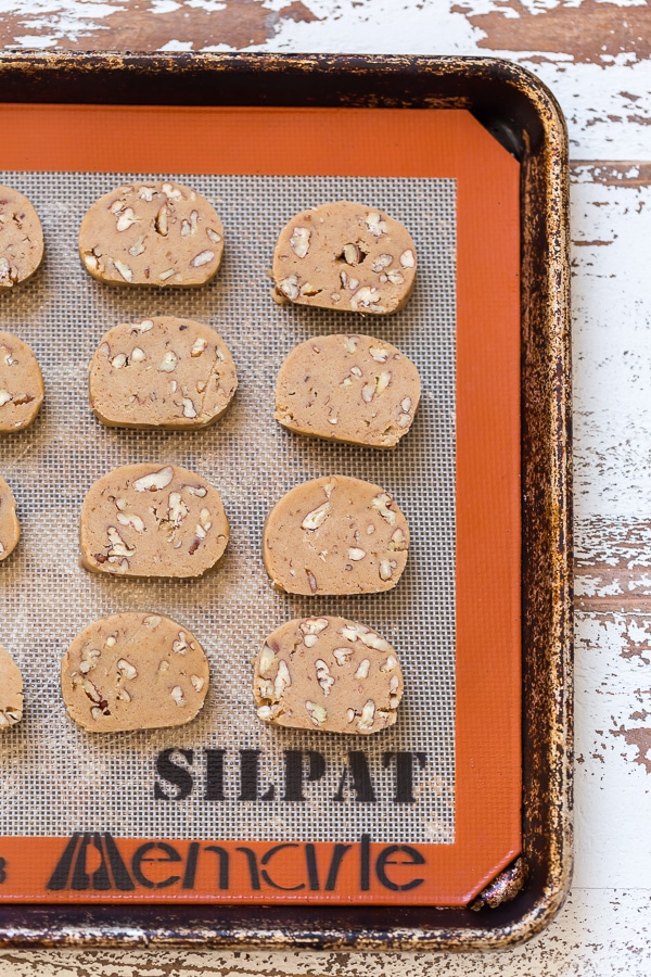 Place the pistachios in a small bowl and cover with water; set aside for 30 minutes. Drain the pistachios well and place them on a paper towel to air dry while you assemble the cookie dough. In the bowl of a stand mixer fitted with the paddle attachment, or in a large bowl using a handheld electric mixer, combine the butter and sugar and beat on medium-high speed until pale and fluffy. Add in the egg and beat until combined. Add in the flour and pistachios and beat until combined. Your dough should be stiff. Sprinkle 2 Tablespoons of flour over a clean work surface. Scrape the cookie dough onto the surface and gently knead it for 30 seconds. Divide the dough in half, then roll each portion of cookie dough into a log that's roughly 2" in diameter. Wrap each log tightly in plastic wrap and refrigerate for at least 2 hours (or up to 5 days). When you're ready to bake, preheat the oven to 350 degrees (F). Line a large baking sheet with parchment paper or a Silpat baking mat. Remove the dough from the fridge and place it on a cutting board. Using a sharp knife, slice the logs of cookie dough into 1/4" rounds. Place the cookies 1/2" apart on the prepared baking sheet, and bake for 10 to 12 minutes, or until lightly golden. Remove the oven and place the pan on a cooling rack. Cool for at least 15 minutes before removing. In the meantime, make the chocolate coating. Melt the chopped chocolate in a double boiler or in the microwave. If using the microwave method, place the chopped chocolate in a medium heat-proof bowl. Melt in the microwave, on low power, in 15 second increments, stirring after each increment until completely melted and smooth. Dip each cookie halfway into the chocolate then return to the lined baking sheet. Sprinkle with sea salt or additional chopped pistachios, if desired. Allow the chocolate to set before serving. To speed this up, place the baking sheet into the refrigerator. Once set, serve and enjoy! These are really good with coffee or tea.