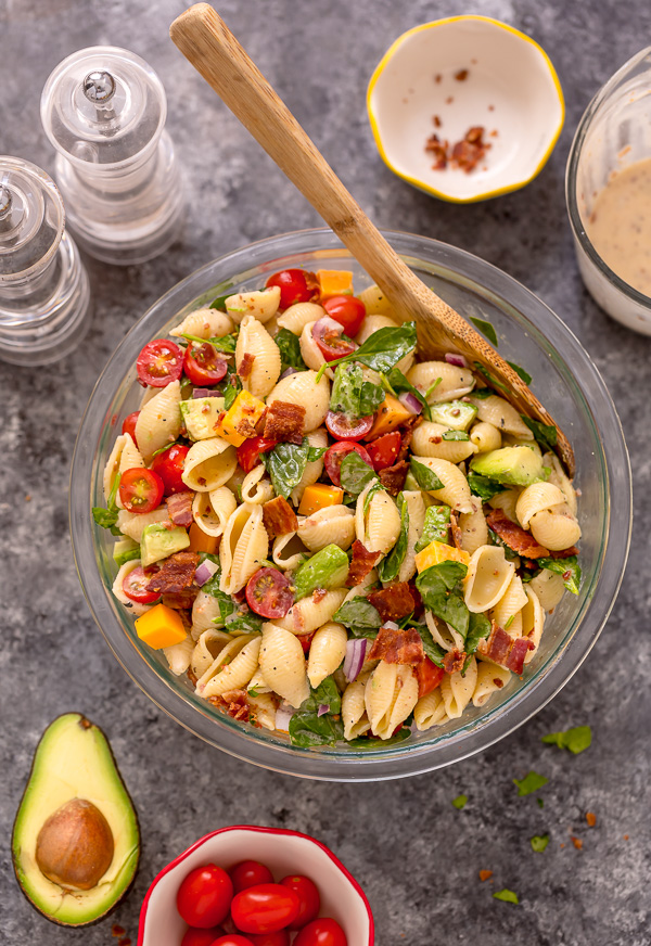 This Creamy Avocado BLT Pasta Salad is so easy and perfect for Summer celebrations! Loaded with crispy bacon, juicy tomatoes, spinach, avocado, and cheddar cheese. This flavorful pasta salad is always a crowd-pleaser!