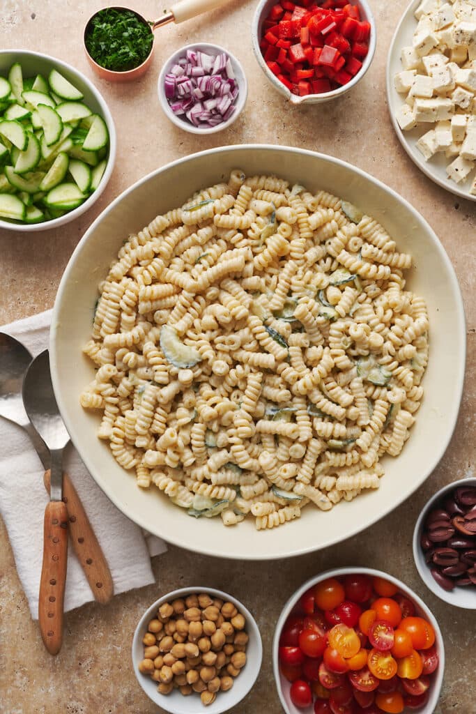 Creamy Greek salad dressing on top of pasta shapes.