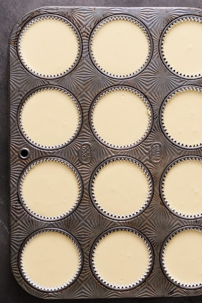 Cupcake liners filled with cheesecake batter.