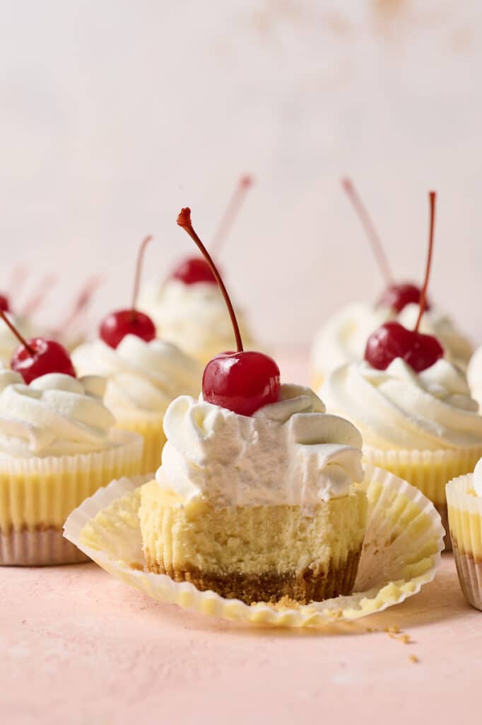Mini cheesecakes in cupcake liners with a bite taken out. 