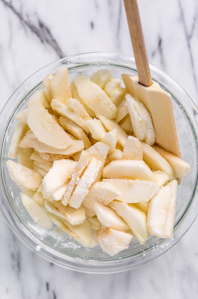 Apple pie filling for apple pie bars in a mixing bowl.