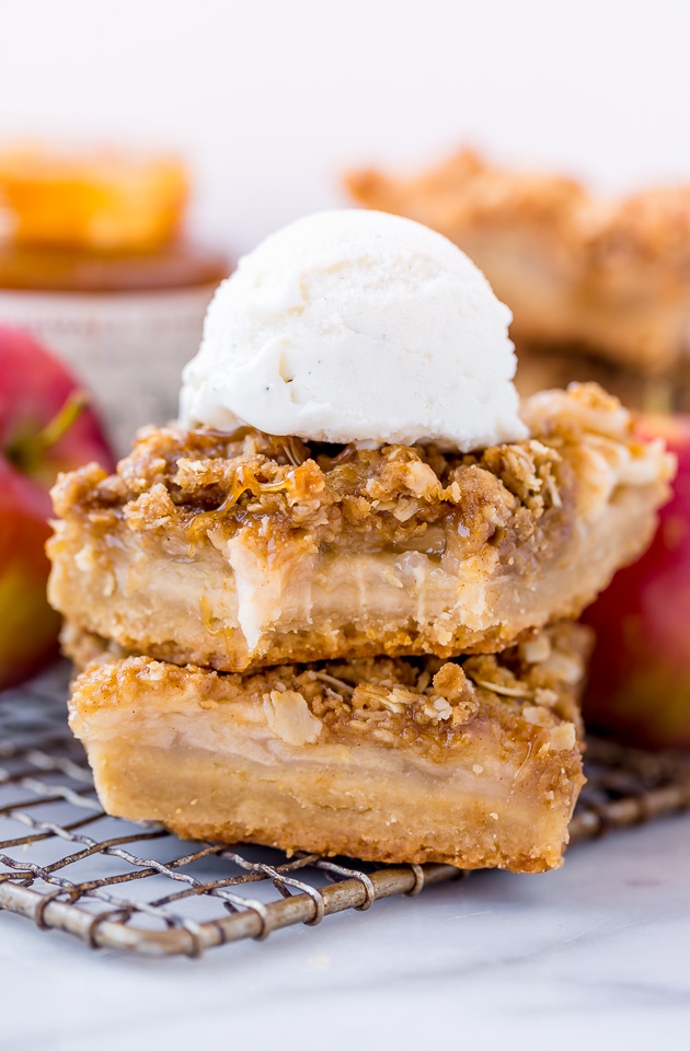 Apple Crisp Bars in a stack with ice cream on top.
