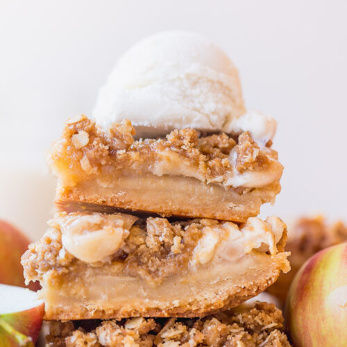 Apple Crisp Bars in a stack with vanilla ice cream on top.