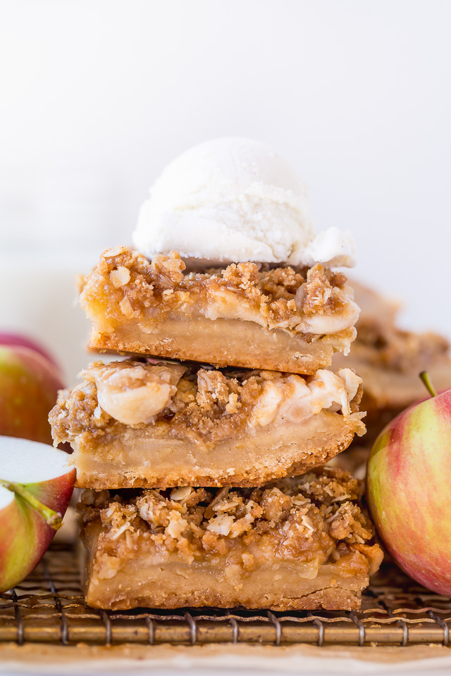 Apple pie bars in a stack with ice cream on top.