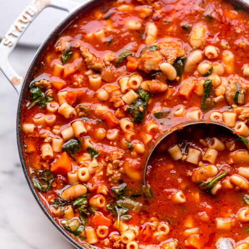 Large pot of pasta fagioli soup with ladle.
