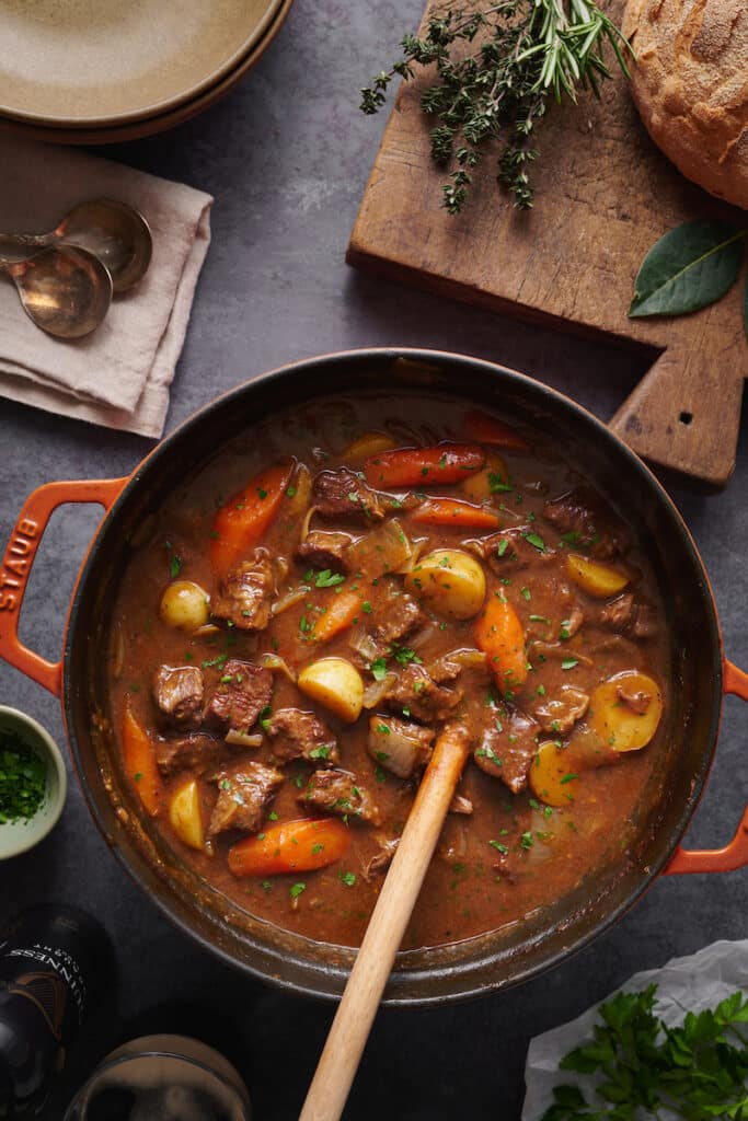 Beef stew in a dutch oven with serving spoon.