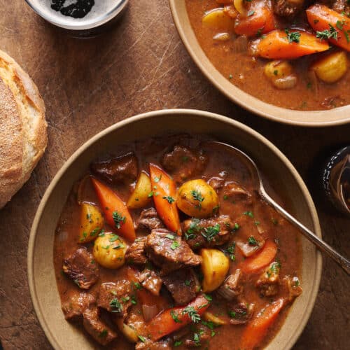 Bowl of Guinness beef stew with a Guinness beer on the side.
