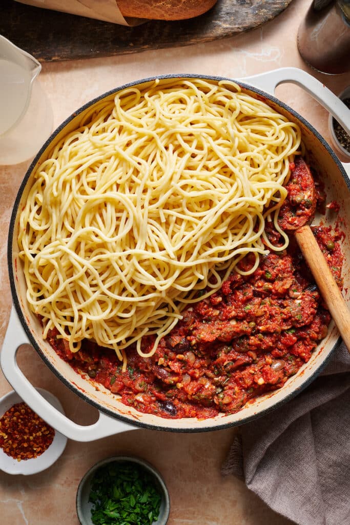Spaghetti with puttanesca sauce on top.