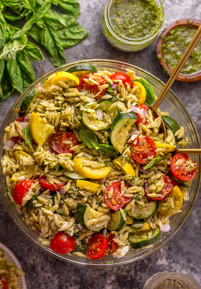 It's beginning to feel a lot like Summer, and you know what that means, right? It's PASTA SALAD SEASON! And this Pesto Orzo Pasta Salad with Zucchini, Goat Cheese, and Tomatoes is sure to be on heavy rotation all Summer long! This mayo-free pasta salad is vegetarian friendly and perfect for picnics, potlucks, and barbecues! #pestopastasalad #pesto #orzo #orzopastasalad